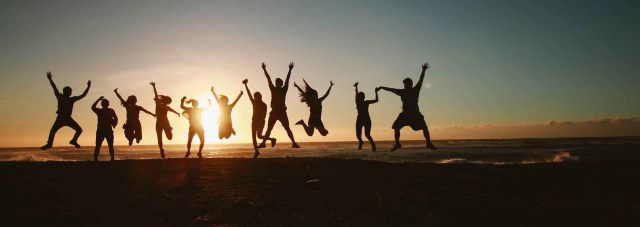 silhouette photography of group of people jumping during golden time